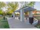 A community picnic area with a shaded structure, tables and seats, trash receptacles, and a pathway leading to a park at 2239 S Cottonwood --, Mesa, AZ 85202