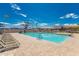 Community pool area showcasing ample seating, lifeguard equipment, shade structures, and clear blue water at 2239 S Cottonwood --, Mesa, AZ 85202