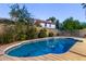 Backyard pool surrounded by a concrete pool deck, block wall, trees, and the back of the house at 2239 S Cottonwood --, Mesa, AZ 85202