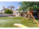 Lush backyard with artificial turf, a play set and slide, and patio with outdoor furniture at 2305 E Millbrae Ct, Gilbert, AZ 85234