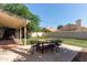 Spacious backyard featuring artificial turf, a covered patio, and a playground area with swing set at 2305 E Millbrae Ct, Gilbert, AZ 85234