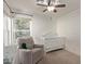 Bedroom bedroom with white walls, ceiling fan, crib and rocking chair at 2305 E Millbrae Ct, Gilbert, AZ 85234