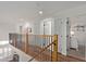 Bright upstairs hallway with wood floors and black iron railing at 2305 E Millbrae Ct, Gilbert, AZ 85234