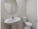 A powder room with a white pedestal sink and a round mirror for a clean, contemporary feel at 2428 S 246Th Ln, Buckeye, AZ 85326