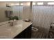 Well-lit bathroom showcasing a vanity with solid countertop, decorative shower curtain, and tiled flooring at 2665 E Gillcrest Rd, Gilbert, AZ 85298