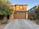 Two-story home featuring a stone column and a brown two-car garage against a blue sky at 2665 E Gillcrest Rd, Gilbert, AZ 85298