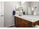 A bright bathroom features a wooden vanity with a single sink and a large mirror above at 2727 N Price Rd # 3, Chandler, AZ 85224