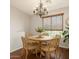 A dining room has a wooden table with seating for five, with a decorative chandelier and wood-look blinds at 2727 N Price Rd # 3, Chandler, AZ 85224