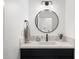 Modern bathroom featuring a round mirror, sleek black fixtures, and light countertops, creating a clean, minimalist aesthetic at 28990 N White Feather Ln # 121, Scottsdale, AZ 85262