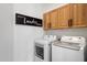 Well-equipped laundry room with modern washer and dryer, along with overhead storage cabinets for organized convenience at 28990 N White Feather Ln # 121, Scottsdale, AZ 85262