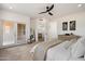Serene main bedroom with light-filled windows, neutral tones, ceiling fan, and doorway to an ensuite bathroom and private balcony at 28990 N White Feather Ln # 121, Scottsdale, AZ 85262