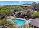 Beautiful pool and hot tub surrounded by desert landscape, boulders, and lush greenery in a gated community at 28990 N White Feather Ln # 121, Scottsdale, AZ 85262