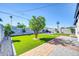 Lush backyard featuring green grass, decorative brickwork, and comfortable outdoor seating area at 2926 N 16Th Ave, Phoenix, AZ 85015