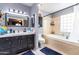 Bathroom featuring a bathtub, white tile, single sink vanity with storage, mirror, and new lighting at 3029 W Sierra St, Phoenix, AZ 85029