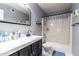 Bathroom with a black framed mirror, toilet, and shower-tub combo with a white shower curtain at 3029 W Sierra St, Phoenix, AZ 85029