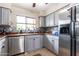 This kitchen features stainless steel appliances, light grey cabinets, and a decorative backsplash at 3029 W Sierra St, Phoenix, AZ 85029