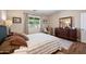 Well lit bedroom featuring a Queen size bed, dresser, sitting chair, and window to a lush backyard at 3117 S Signal Butte Rd # 484, Mesa, AZ 85212