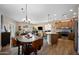 Open-concept kitchen and dining area with wood floors, island, and updated stainless appliances at 3117 S Signal Butte Rd # 484, Mesa, AZ 85212