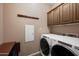 Functional laundry room with a modern, front-load washer and dryer, and built-in storage cabinets at 3117 S Signal Butte Rd # 484, Mesa, AZ 85212