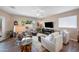 Bright living room featuring a ceiling fan, tv, comfortable seating and a window showcasing the lush exterior at 3117 S Signal Butte Rd # 484, Mesa, AZ 85212