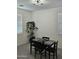 A modern dining room setup with a table and chairs sits beneath a stylish ceiling fan at 36354 W San Clemente Ave, Maricopa, AZ 85138