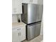 The kitchen has a stainless-steel refrigerator, white cabinets and subway tile backsplash at 36354 W San Clemente Ave, Maricopa, AZ 85138