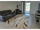 Cozy living room showcases a comfortable sofa, chairs, tile flooring, and sliding glass doors to the yard at 36354 W San Clemente Ave, Maricopa, AZ 85138