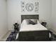 The primary bedroom is furnished with a gray bed frame, two side tables, and decorative wall art at 36354 W San Clemente Ave, Maricopa, AZ 85138