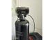 A black water softener installed inside a home to filter and soften water at 36354 W San Clemente Ave, Maricopa, AZ 85138