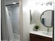 Well-lit bathroom with a shower-tub, modern vanity, and a round mirror, creating a clean and inviting space at 3650 E Montecito Ave # 4, Phoenix, AZ 85018