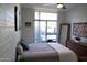 Bright bedroom featuring a ceiling fan, modern decor, and access to an outdoor patio at 3650 E Montecito Ave # 4, Phoenix, AZ 85018