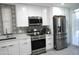 Modern kitchen with white cabinets, stainless steel appliances, and stylish backsplash at 3650 E Montecito Ave # 4, Phoenix, AZ 85018
