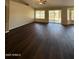 A large living room features neutral walls, wood floors, and multiple windows with backyard access at 3700 E Sandwick Dr, San Tan Valley, AZ 85140
