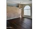 Bright living room with hardwood floors, decorative wall, and an arched window at 3700 E Sandwick Dr, San Tan Valley, AZ 85140