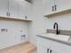 Laundry room features white cabinets, gray countertops and modern fixtures at 4007 N 34Th St, Phoenix, AZ 85018