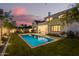 Stunning backyard view with a sparkling pool, lush lawn, and stylish seating area at dusk at 4007 N 34Th St, Phoenix, AZ 85018