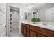 Bathroom featuring double sink vanity with wood cabinets and a large mirror at 4115 S 180Th Dr, Goodyear, AZ 85338