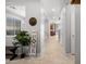 Bright hallway with tiled floors, grey walls, decorative items, and an entrance to the kitchen at 4115 S 180Th Dr, Goodyear, AZ 85338