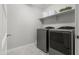 Bright laundry room featuring new washer and dryer with storage shelf and tile flooring at 4115 S 180Th Dr, Goodyear, AZ 85338