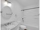 Updated bathroom with a marble vanity, round mirror, and shower over tub at 4337 E Wilshire Dr, Phoenix, AZ 85008