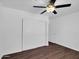 Bright bedroom featuring wood-look flooring, ceiling fan and closet with sliding doors at 4337 E Wilshire Dr, Phoenix, AZ 85008