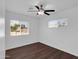 Bright bedroom featuring wood-look flooring, ceiling fan, and two sunlit windows at 4337 E Wilshire Dr, Phoenix, AZ 85008