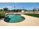 Backyard pool with rock waterfall feature, lush landscaping, and expansive concrete patio at 4337 E Wilshire Dr, Phoenix, AZ 85008