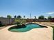 Backyard pool with rock waterfall feature surrounded by stone and low maintenance landscaping at 4337 E Wilshire Dr, Phoenix, AZ 85008