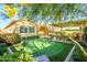 Secluded backyard features a putting green, shaded seating, a lush landscape, and mature trees at 4450 S Frequency --, Mesa, AZ 85212