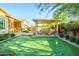Lush backyard features a putting green, covered seating area, and manicured landscaping at 4450 S Frequency --, Mesa, AZ 85212