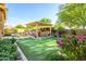 Inviting backyard features a putting green, covered seating area, and well-manicured landscaping at 4450 S Frequency --, Mesa, AZ 85212