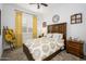 Cozy bedroom featuring wood furnishings, a large decorative clock, and bright yellow accents at 4450 S Frequency --, Mesa, AZ 85212