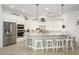 Bright, modern kitchen with white cabinets, stainless steel appliances, large island, and stylish pendant lighting at 4450 S Frequency --, Mesa, AZ 85212