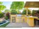 Well-equipped outdoor kitchen boasts a built-in grill, mini fridge, and bar seating near the pool at 4450 S Frequency --, Mesa, AZ 85212